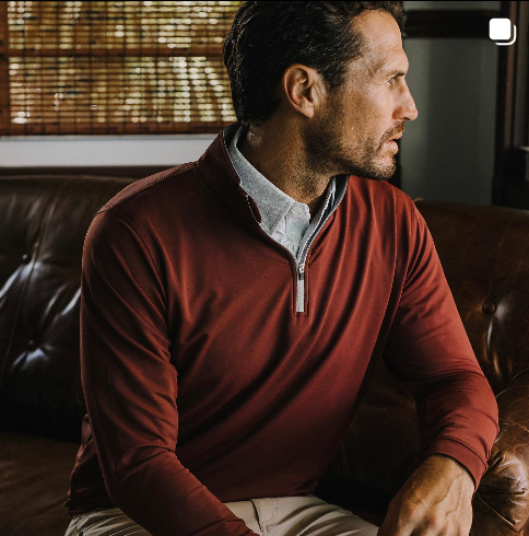 Man sitting on a couch in GenTeal mens clothing.